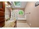 Bright bathroom featuring a skylight, granite countertop, a soaking tub, and a walk-in shower for a spa-like experience at 1030 W Sterlington Pl, Apex, NC 27502