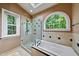 Luxurious bathroom with a walk-in shower, soaking tub, and natural light perfect for relaxation at 1030 W Sterlington Pl, Apex, NC 27502