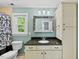Well-lit bathroom features a vanity with a dark countertop, a mirror, and a toilet at 1030 W Sterlington Pl, Apex, NC 27502