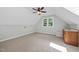Bright bonus room featuring neutral carpet, a window, ceiling fan, and a convenient wet bar at 1030 W Sterlington Pl, Apex, NC 27502