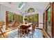 Bright dining room featuring a skylight, dark-wood trim, and a view of the surrounding forest at 1030 W Sterlington Pl, Apex, NC 27502