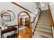 Welcoming foyer featuring hardwood floors, an elegant staircase, and archway to the dining room at 1030 W Sterlington Pl, Apex, NC 27502