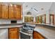 Modern kitchen featuring stainless steel oven, granite countertops, and wood cabinets at 1030 W Sterlington Pl, Apex, NC 27502