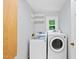 Well-lit laundry room equipped with a washer, dryer, and shelving at 1030 W Sterlington Pl, Apex, NC 27502