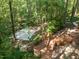 Wooded backyard featuring an outdoor basketball court and extensive deck with stairs at 104 Warley Cir, Cary, NC 27513