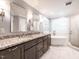 A luxurious bathroom features dual sinks, a soaking tub under a window, and a walk-in shower at 104 Warley Cir, Cary, NC 27513