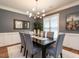 Dining room featuring modern light fixture, a black table with six chairs, and hardwood floors at 104 Warley Cir, Cary, NC 27513