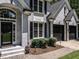 Close-up of a gray brick home entrance with black shutters and a two-car garage at 104 Warley Cir, Cary, NC 27513