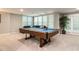 Spacious game room with a pool table, comfortable seating, and natural light from large windows at 104 Warley Cir, Cary, NC 27513