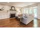 Cozy living room with fireplace, hardwood floors, and large windows offering natural light at 104 Warley Cir, Cary, NC 27513