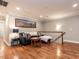 Cozy living room with hardwood floors, comfortable seating, and decorative baseball stadium wall art at 104 Warley Cir, Cary, NC 27513