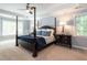 Spacious main bedroom featuring a four-poster bed, neutral walls, and bright, natural light at 104 Warley Cir, Cary, NC 27513