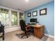 Functional office space with natural light, a wooden desk, and framed certificates on the blue wall at 104 Warley Cir, Cary, NC 27513