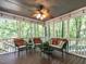 Relaxing screened porch with overhead fan and comfortable wicker furniture surrounded by lush greenery at 104 Warley Cir, Cary, NC 27513