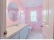 A vintage bathroom with soft pink walls and blue accents, including a pastel blue vanity at 10625 Soma Ct, Raleigh, NC 27613