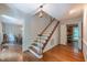 Inviting foyer features hardwood floors, stairs with white banisters, and an elegant light fixture at 10625 Soma Ct, Raleigh, NC 27613