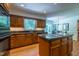 A kitchen with stainless steel appliances, wood cabinets, and a center island with a cooktop at 10625 Soma Ct, Raleigh, NC 27613