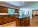 A kitchen featuring stainless steel appliances, wood cabinets, an island, and access to the living room at 10625 Soma Ct, Raleigh, NC 27613