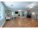 Spacious living room featuring hardwood flooring, a ceiling fan, a TV, and an aquarium at 10625 Soma Ct, Raleigh, NC 27613
