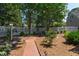 Charming backyard featuring a brick path, dining set, and mature trees at 107 Quarter Path, Cary, NC 27518