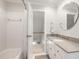 Clean bathroom features a tub/shower combo, white tile, and a modern vanity with a circular mirror at 107 Quarter Path, Cary, NC 27518