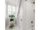 Bright bathroom featuring white tiled shower, shuttered window with plant, and white door at 107 Quarter Path, Cary, NC 27518