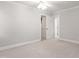 Spacious bedroom with neutral walls, white trim, and open doorway to another room at 107 Quarter Path, Cary, NC 27518