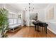 Elegant dining room features hardwood floors, a chandelier, bay windows with shutters, and a grand piano at 107 Quarter Path, Cary, NC 27518