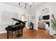 Stylish dining room with hardwood floors, a piano, and open access to the living room and kitchen at 107 Quarter Path, Cary, NC 27518