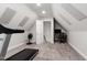 Bright exercise room with sloped ceilings connecting to bonus room or office at 107 Quarter Path, Cary, NC 27518