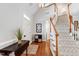 Bright foyer with hardwood floors, a white front door, and a staircase with carpet and wood handrail at 107 Quarter Path, Cary, NC 27518