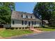 Beautiful one-story house featuring a brick walkway, dormer windows, and lush green lawns at 107 Quarter Path, Cary, NC 27518
