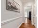 Inviting hallway featuring hardwood floors, elegant wall molding, and artwork for a sophisticated touch at 107 Quarter Path, Cary, NC 27518