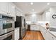 Well-lit kitchen with stainless steel appliances, granite countertops, and white cabinetry at 107 Quarter Path, Cary, NC 27518