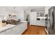Modern eat-in kitchen with white cabinets and granite countertops leads to the living area at 107 Quarter Path, Cary, NC 27518