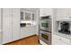 Modern kitchen with white cabinets and stainless appliances with built in microwave and oven at 107 Quarter Path, Cary, NC 27518