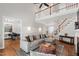 Large living room featuring a fireplace, comfortable seating, hardwood floors, and second-story gallery at 107 Quarter Path, Cary, NC 27518