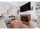 Cozy living room featuring a fireplace, hardwood floors, comfortable seating and an open staircase at 107 Quarter Path, Cary, NC 27518