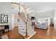 Open living room featuring hardwood floors, fireplace, staircase, and large windows, creating a bright space at 107 Quarter Path, Cary, NC 27518