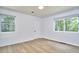 Bright bedroom features updated flooring, fresh white paint, and two windows for ample natural light at 108 Cedar St, Chapel Hill, NC 27514