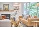 Inviting living room featuring a fireplace and stylish furniture with large windows overlooking the yard at 108 Cedar St, Chapel Hill, NC 27514