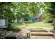 Spacious backyard featuring a garden, outbuilding, manicured landscaping, and mature trees at 109 Fox Trap Ct, Garner, NC 27529
