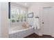 Bathroom with subway tile, large window, soaking tub, and dark hardwood flooring at 109 Fox Trap Ct, Garner, NC 27529