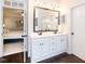 Bathroom with double sink vanity, large mirror, and view into connecting bedroom at 109 Fox Trap Ct, Garner, NC 27529