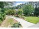 Long, curved driveway leading to a beautiful brick home surrounded by lush greenery and mature trees at 109 Fox Trap Ct, Garner, NC 27529