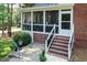 Brick home featuring a screened porch, brick stairs, black iron railing, and manicured landscaping at 109 Fox Trap Ct, Garner, NC 27529