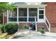 Brick home featuring a screened porch, brick stairs, black iron railing, and manicured landscaping at 109 Fox Trap Ct, Garner, NC 27529