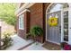 Charming brick home entrance with a welcoming yellow floral wreath on a gray door at 109 Fox Trap Ct, Garner, NC 27529
