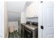 An efficient laundry room with machines, white cabinetry, and green tiled flooring at 109 Fox Trap Ct, Garner, NC 27529