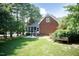 Brick home with screened porch, steps, fenced area, mature trees, and green lawn at 109 Fox Trap Ct, Garner, NC 27529